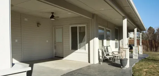 A white house with a porch and a ceiling fan