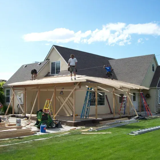 A group of people are working on the roof of a house