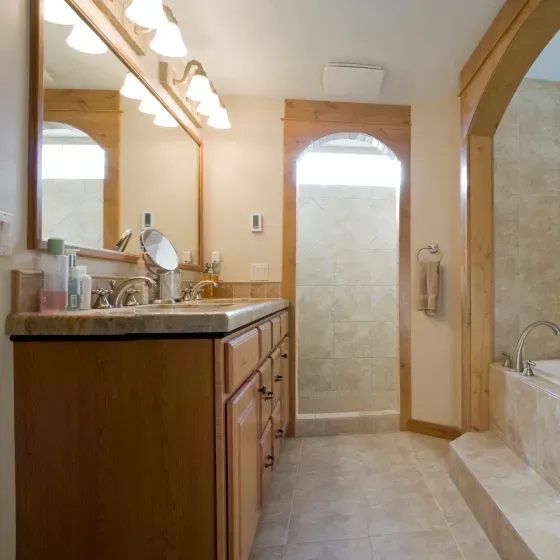 A bathroom with two sinks a mirror and a tub