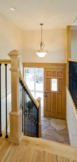 A staircase leading up to a wooden door in a house.