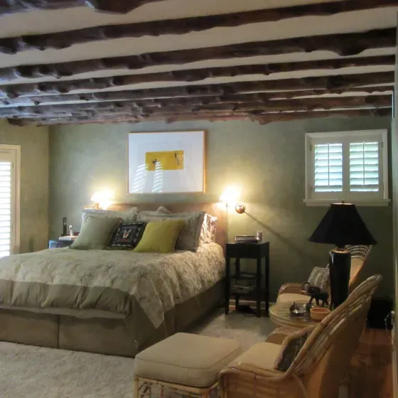 A bedroom with a king size bed and chairs