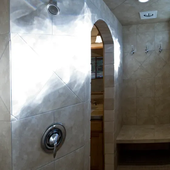 A bathroom with a shower and a bench