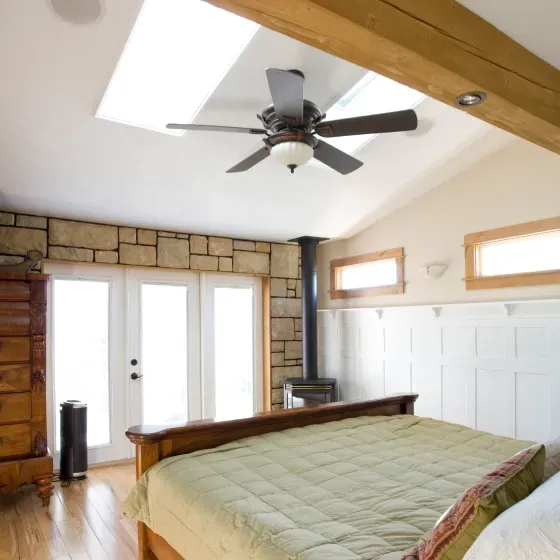 A bedroom with a bed and a ceiling fan
