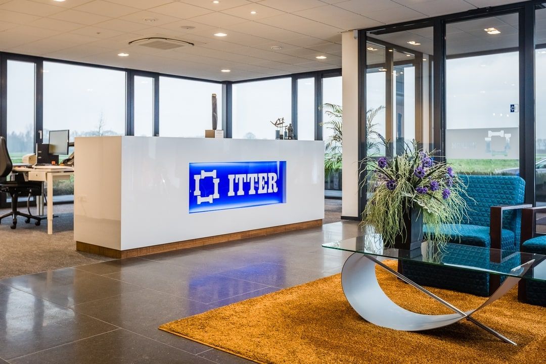 Een lobby met een receptie en een blauwe stoel.