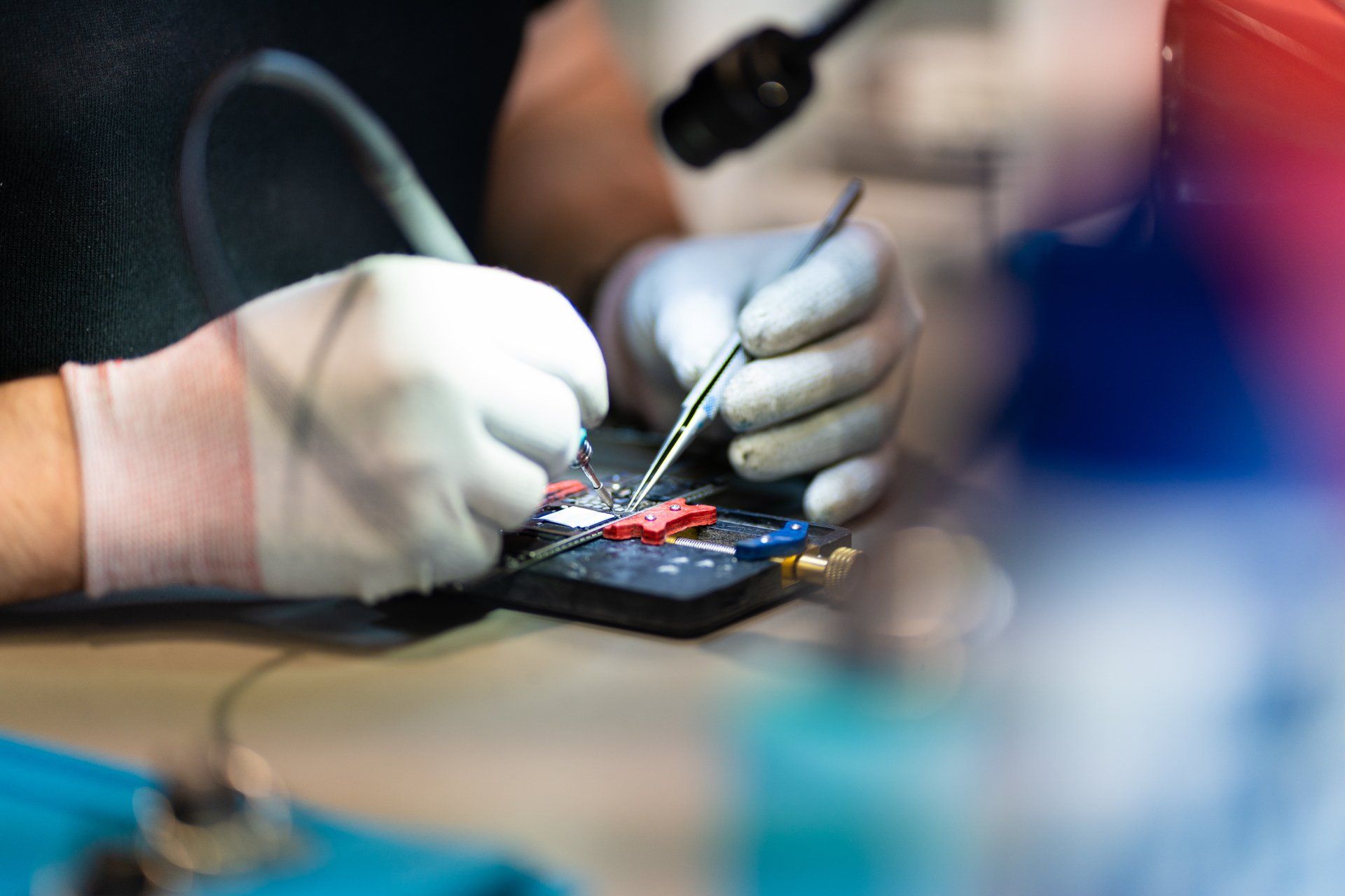 Een close-up van een persoon die een soldeerbout op een printplaat gebruikt.