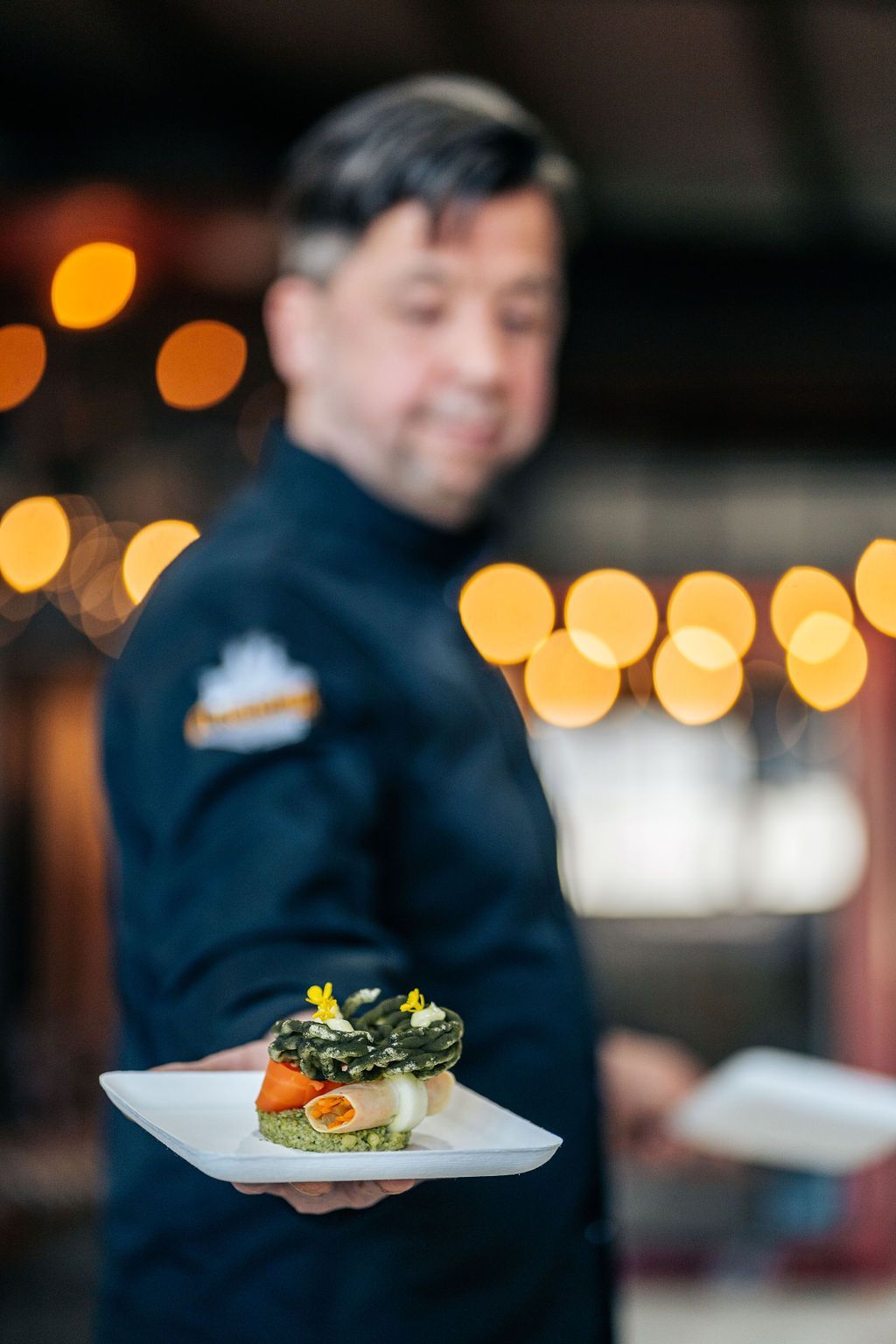 Een man houdt een bord eten in zijn hand.