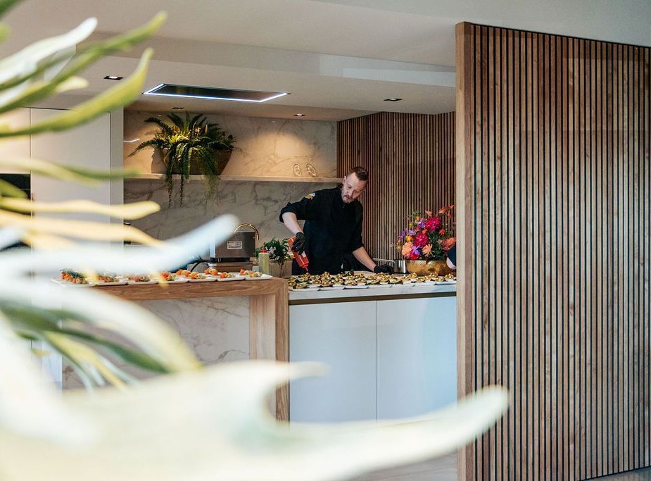 Een man staat in een keuken en bereidt voedsel.