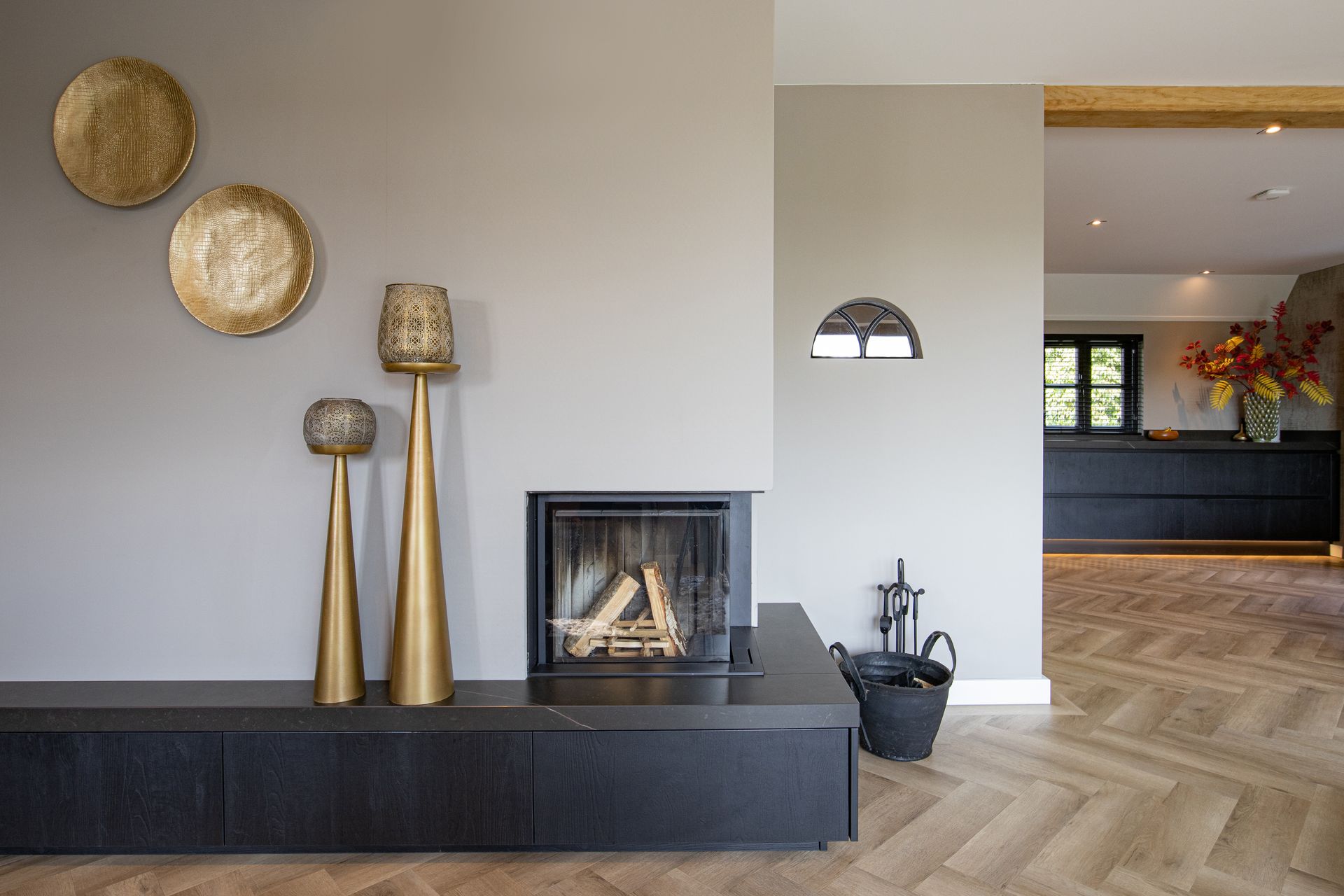 Een woonkamer met open haard en een visgraatvloer