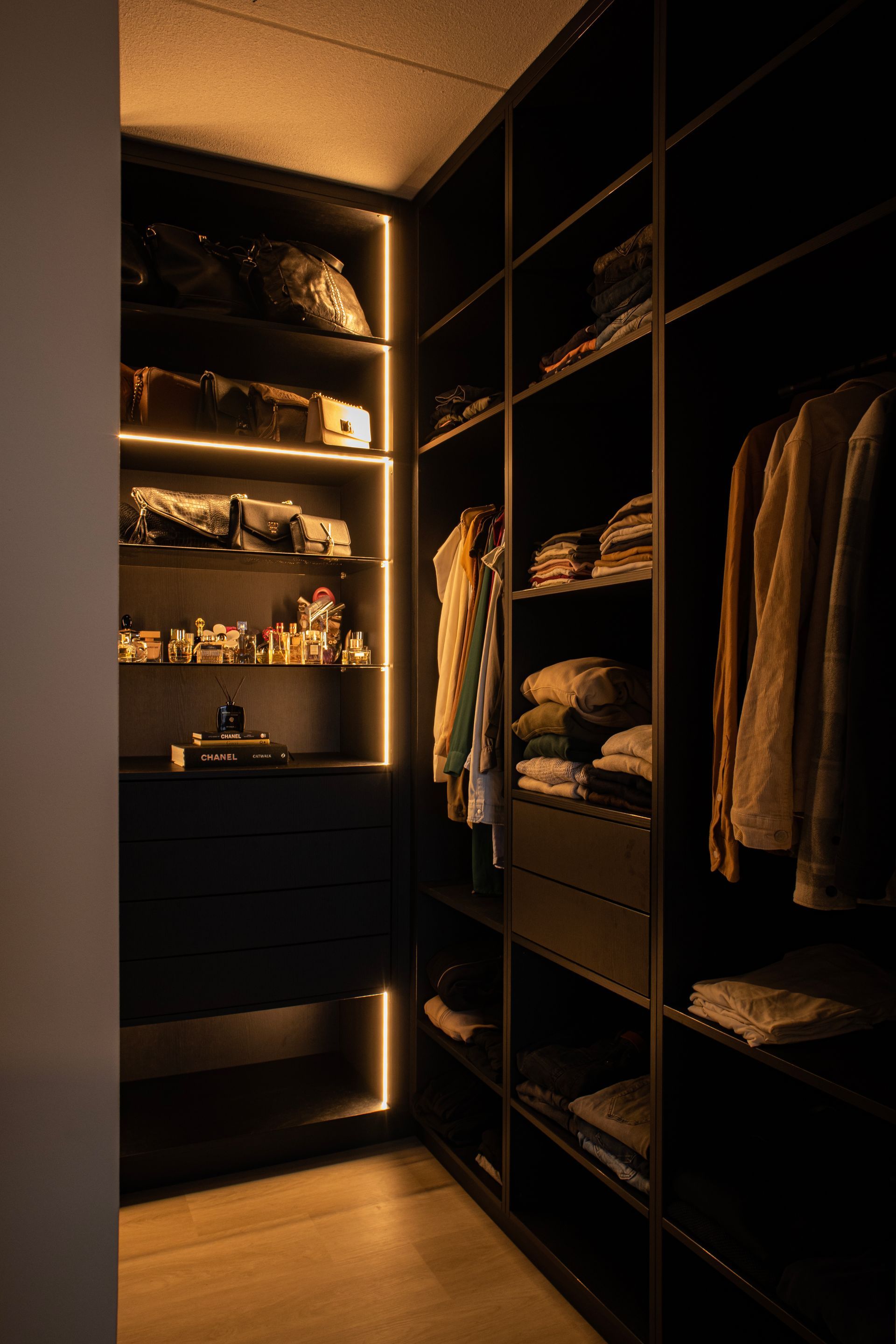 Een inloopkast gevuld met kleding en een dressoir.