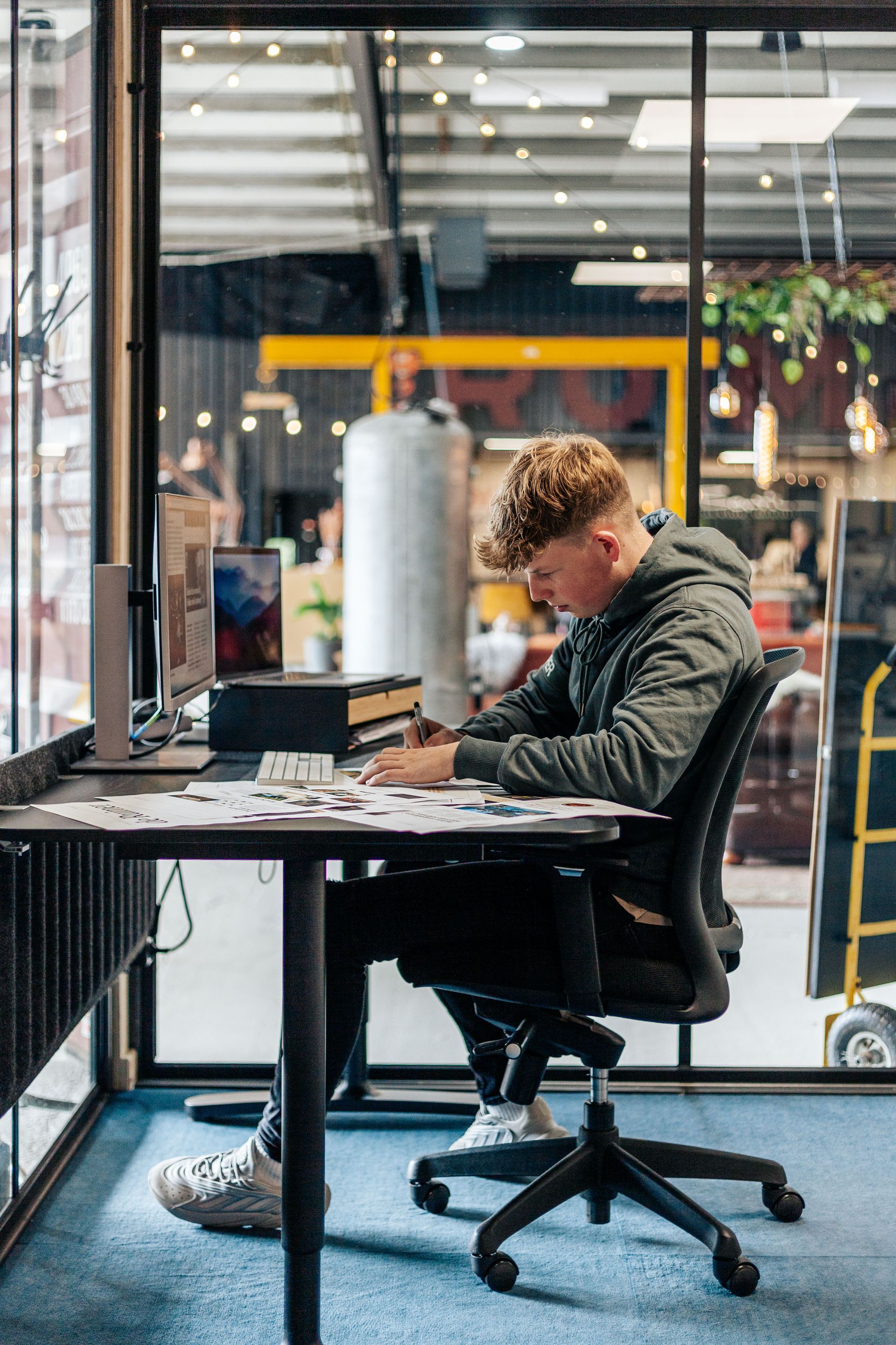 Een man zit aan een bureau achter een computer.