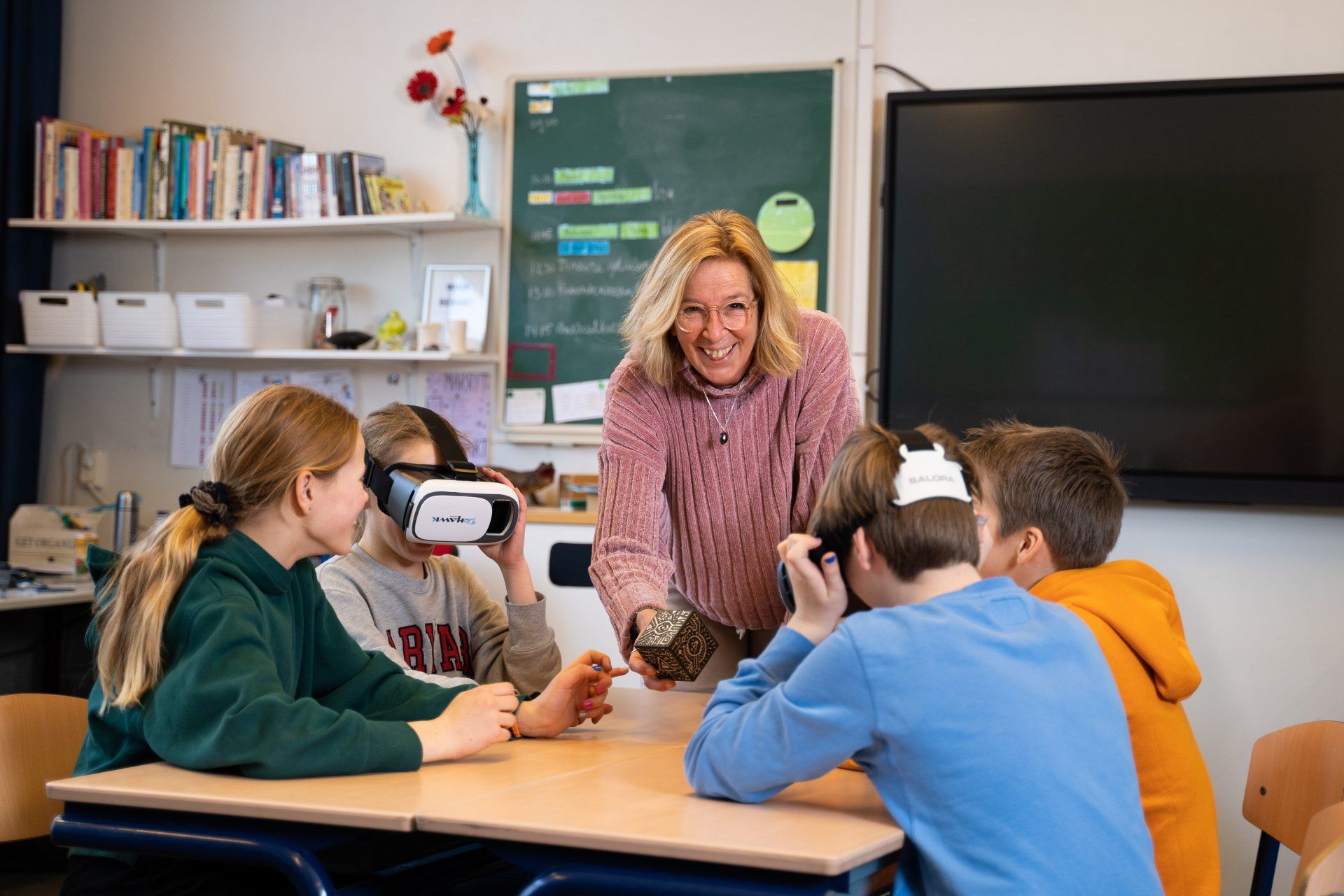 Een groep kinderen draagt een virtual reality-bril in een klaslokaal.