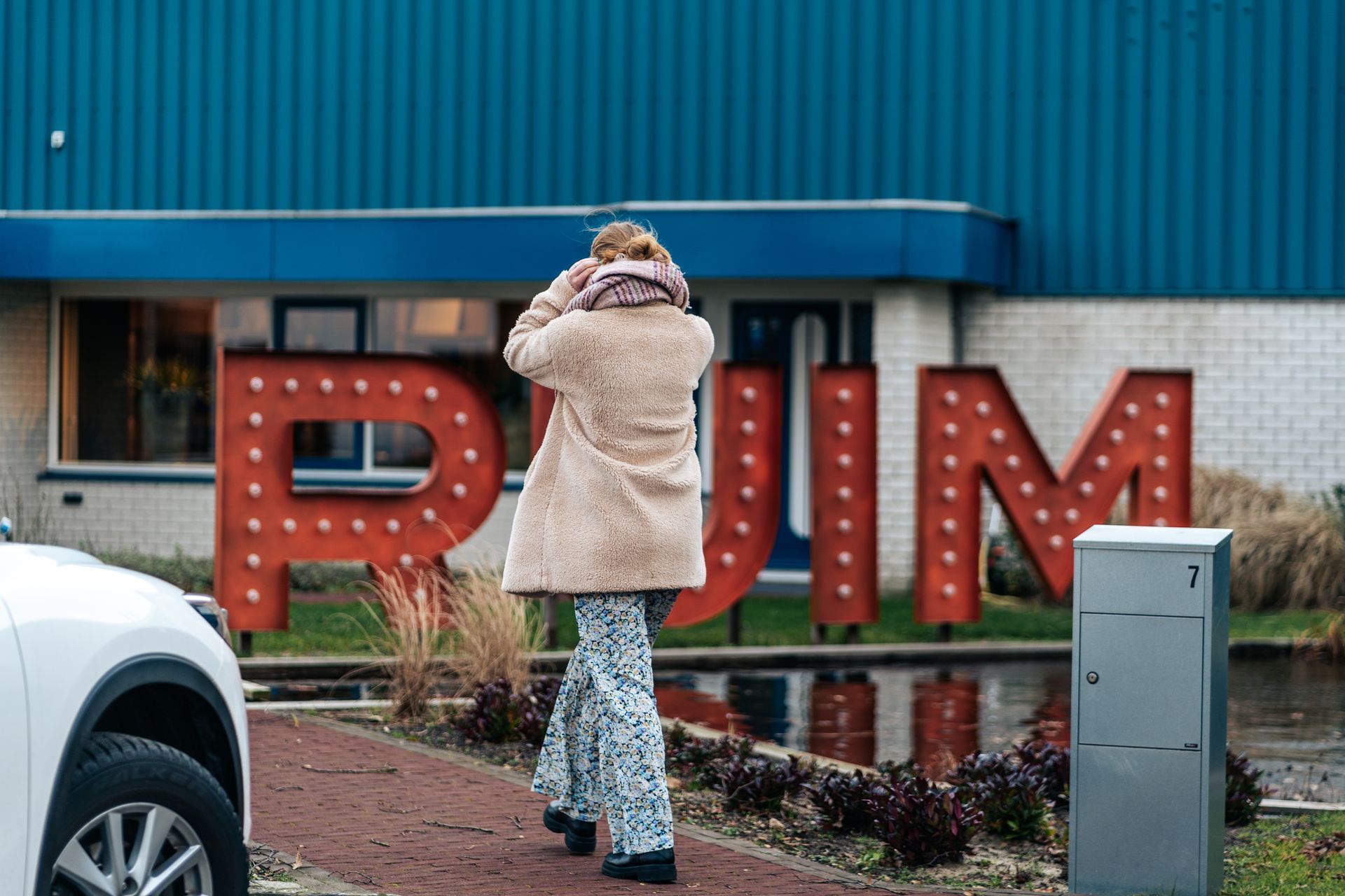 Een vrouw staat voor een groot bord met de tekst rum.