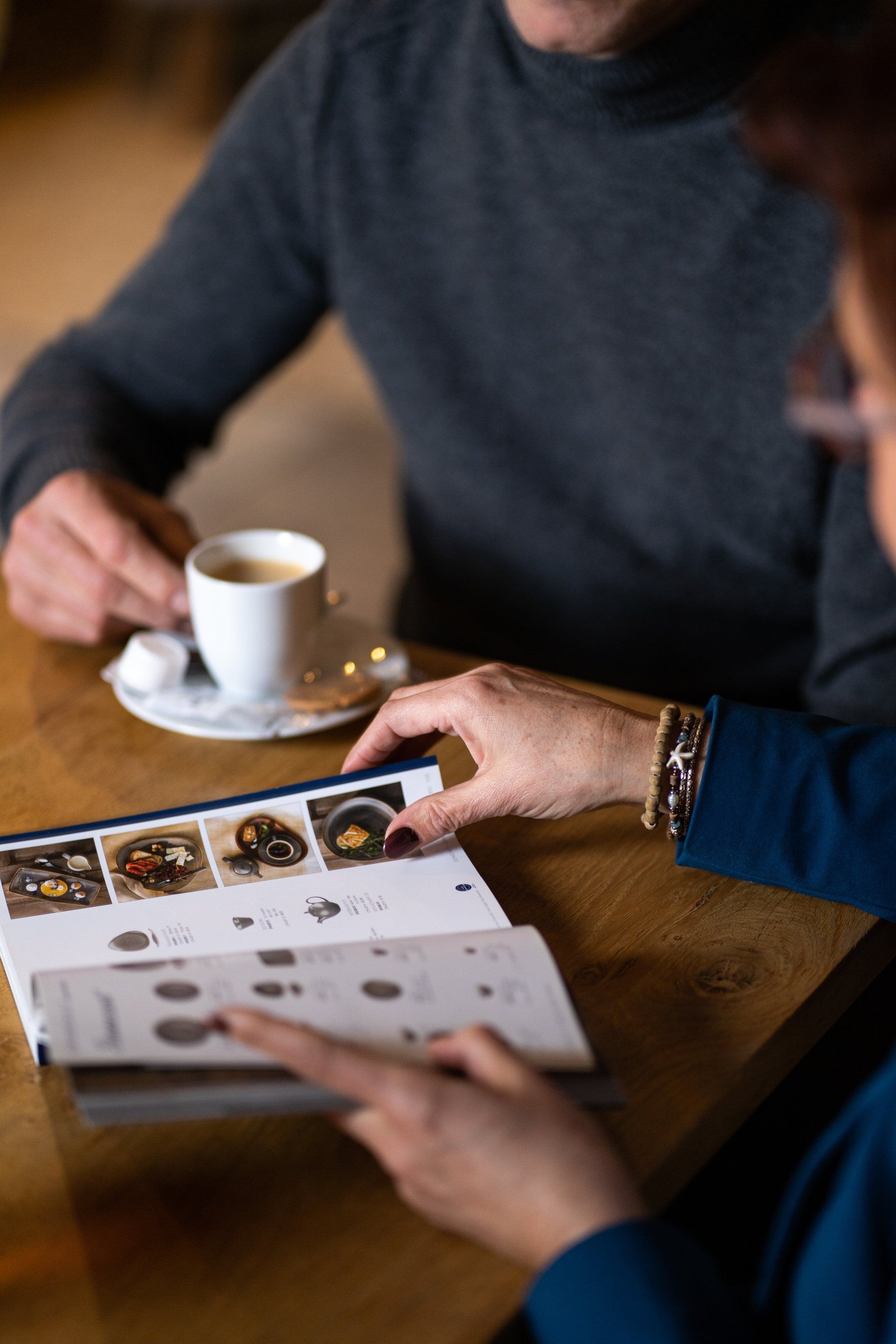 Een man en een vrouw zitten aan een tafel en kijken naar een menukaart.