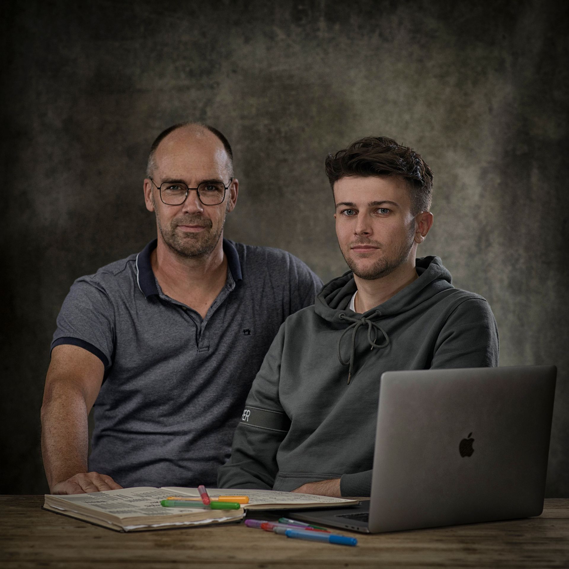 Jan en Mees zitten aan een tafel met een laptop.