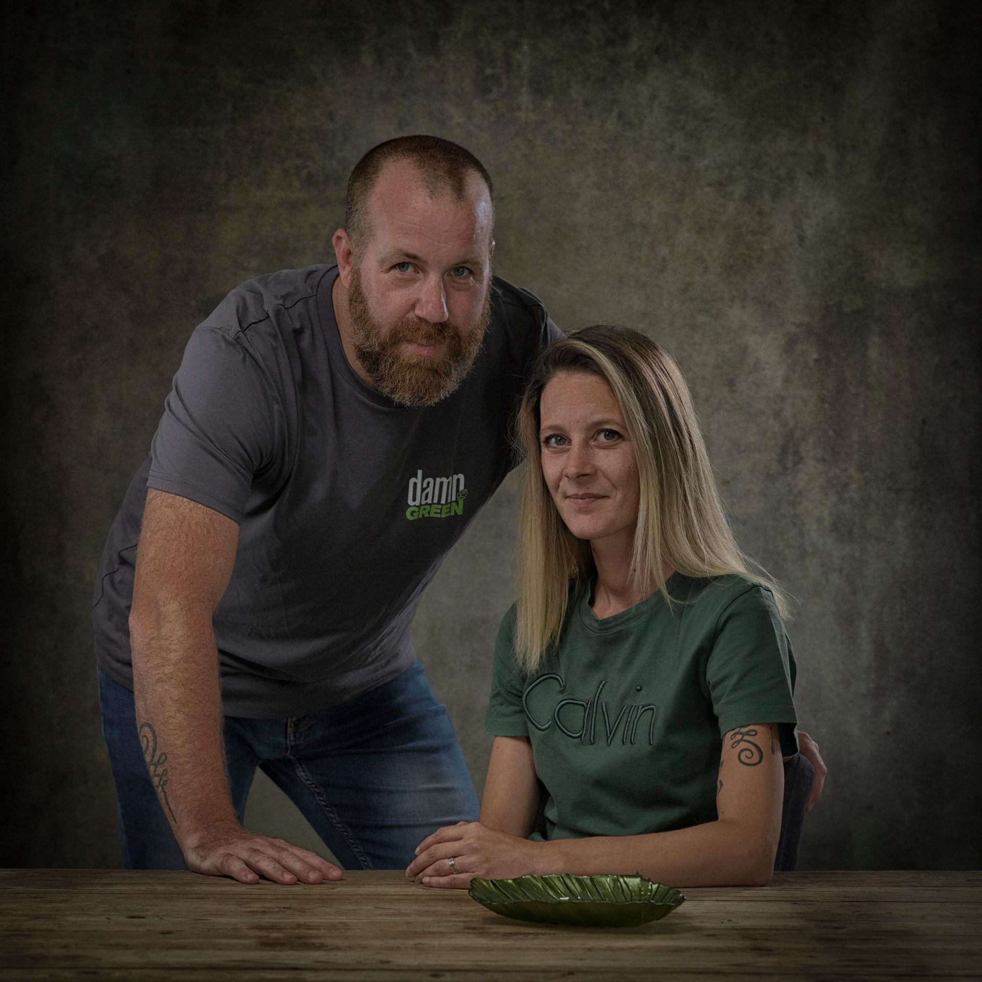 Een man en een vrouw poseren voor een foto terwijl ze aan een tafel zitten.