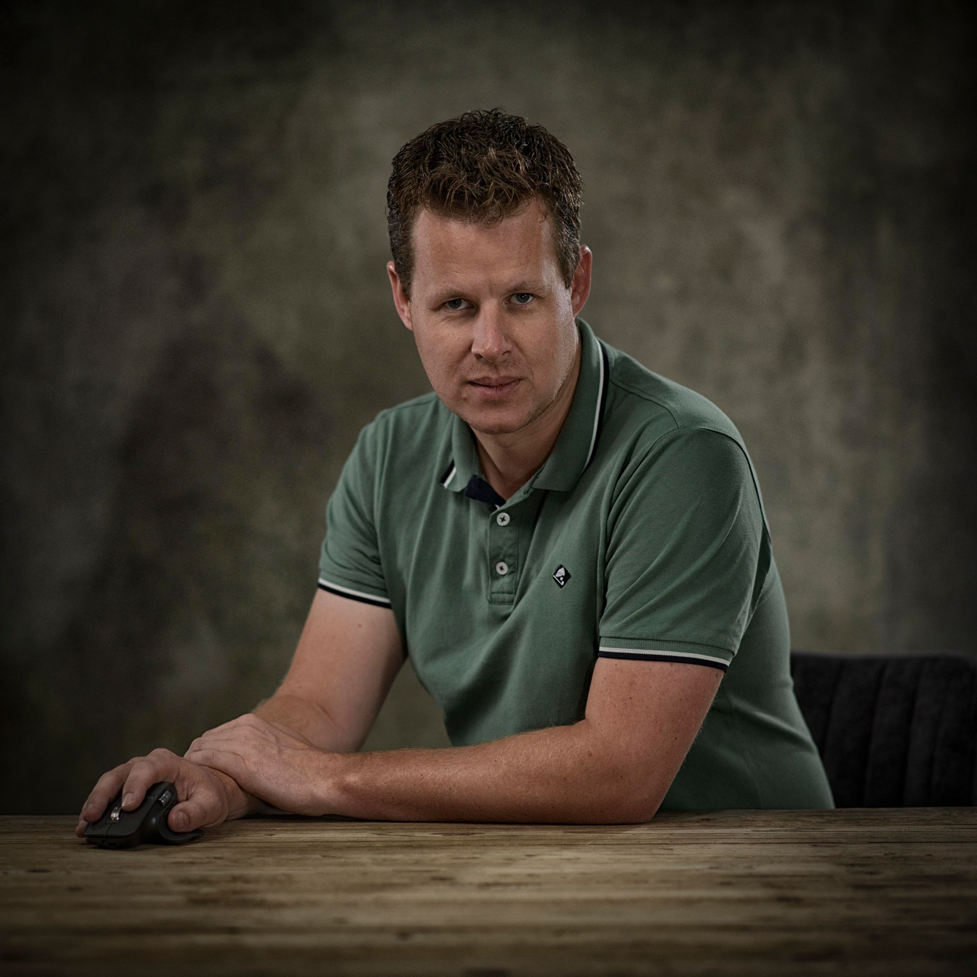 Remco zit aan een tafel en gebruikt een computermuis.