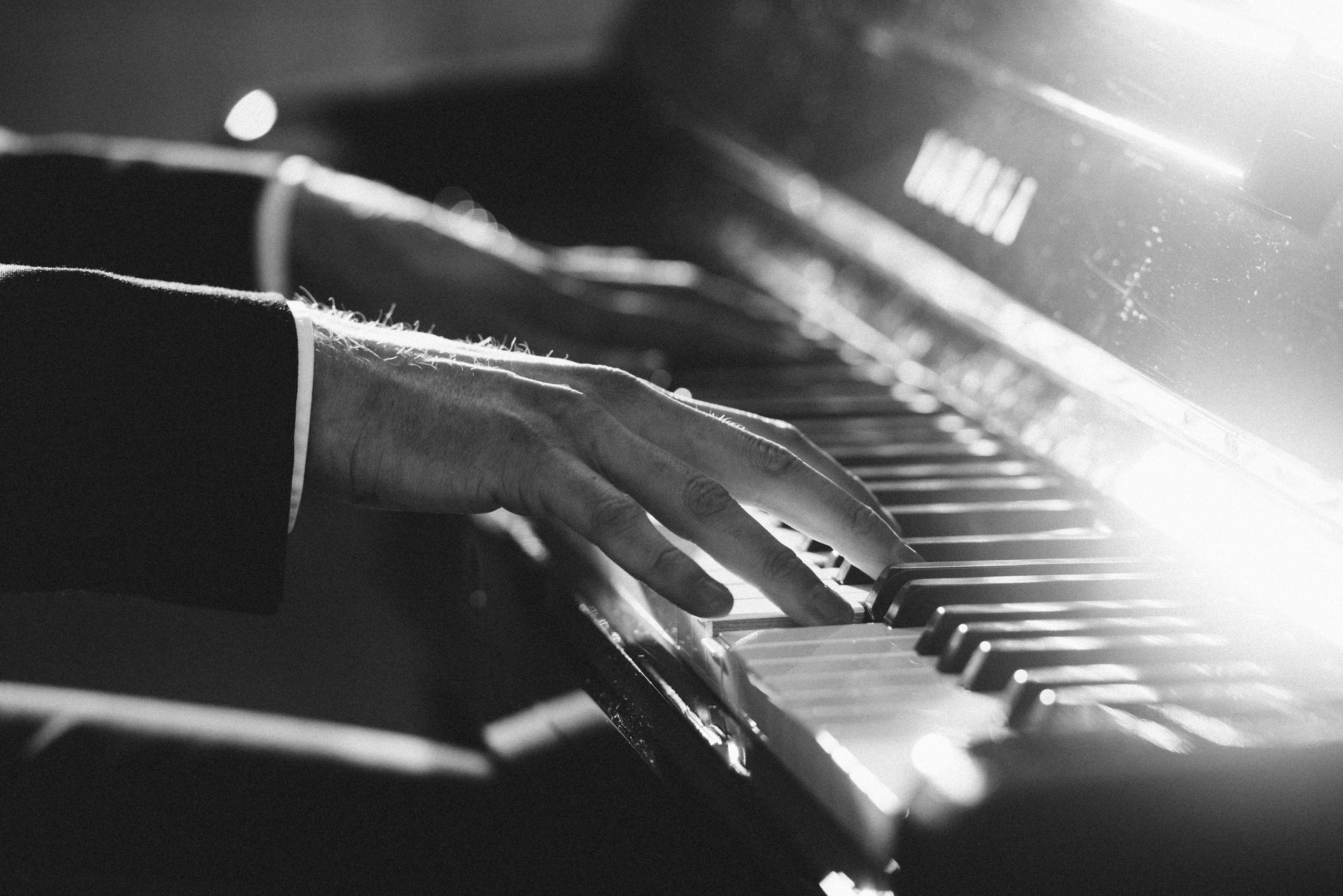 Een zwart-witfoto van een persoon die piano speelt
