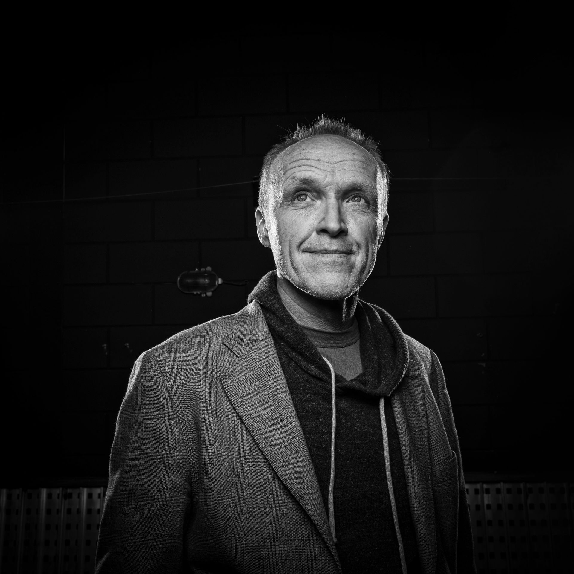 Een zwart-witfoto van een man met een jas.