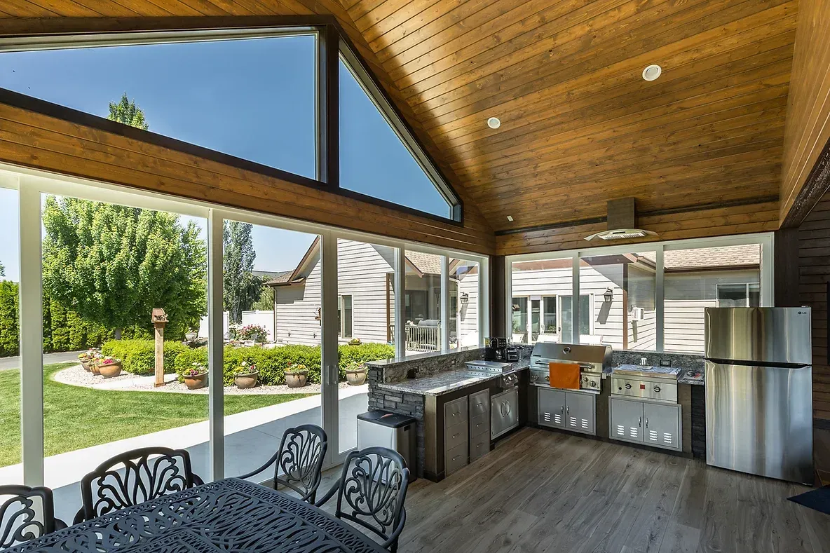 A large room with a lot of windows and a table and chairs.