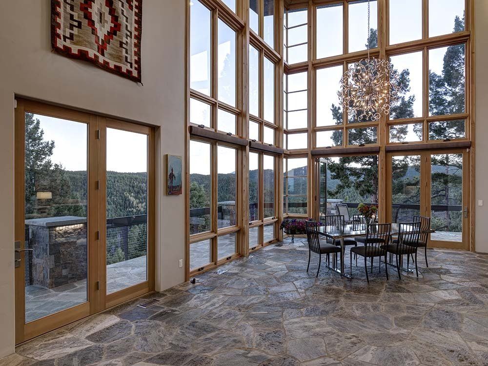 A large room with a lot of windows and a table and chairs