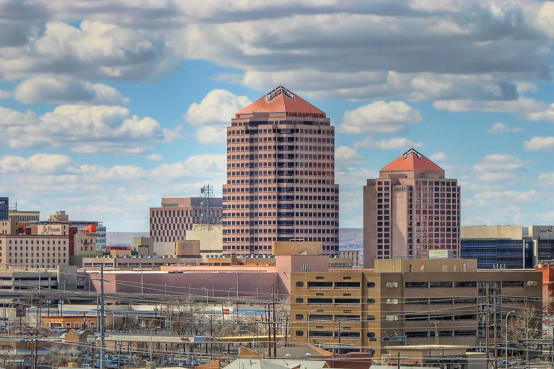 A city skyline with a blue sky and clouds in the background