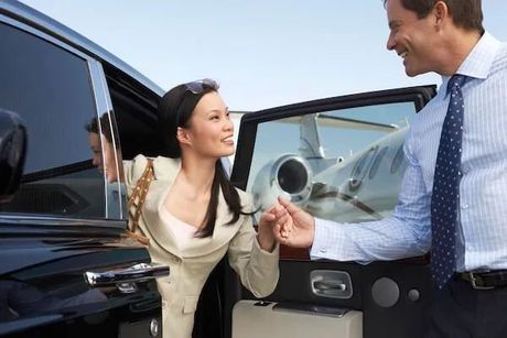 A man is helping a woman get out of a car.