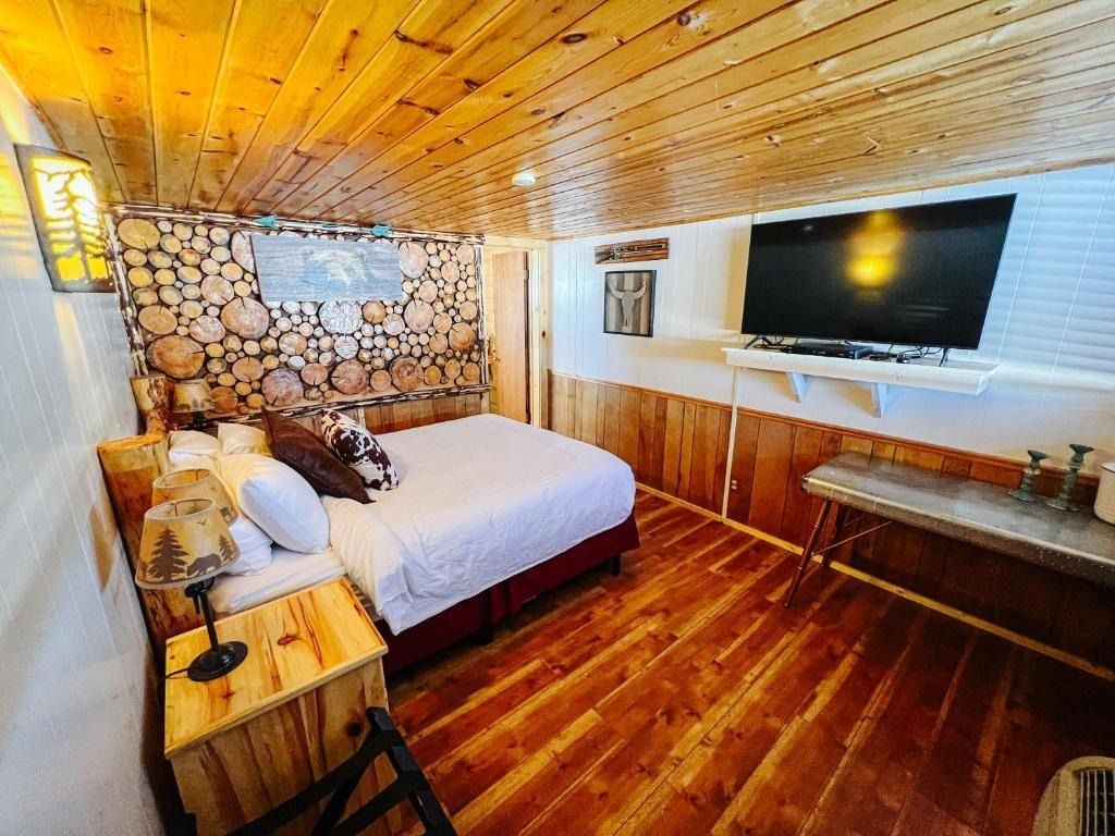 There are two beds in the room with a picture of fish on the wall.