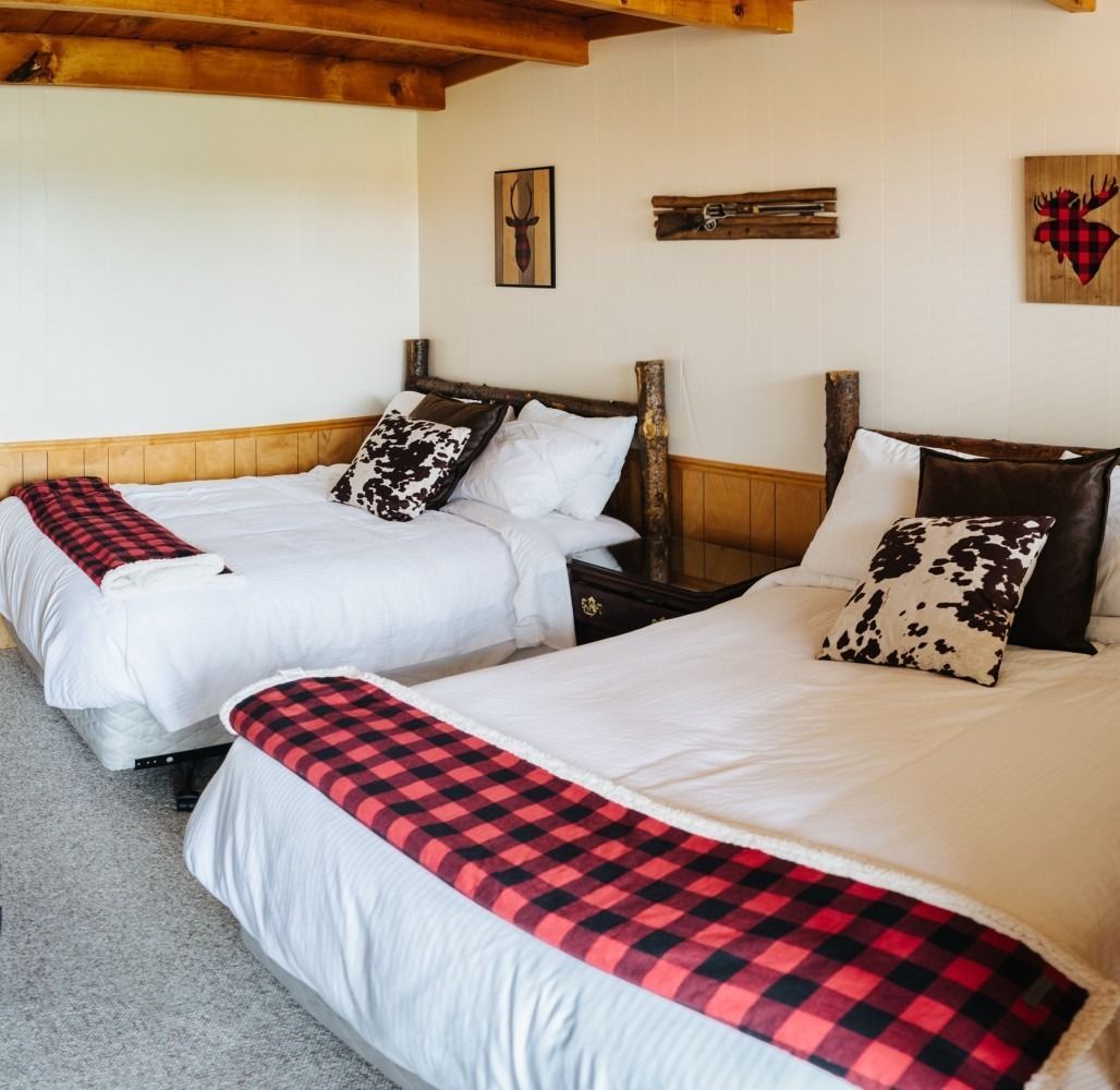 A hotel room with two beds and a flat screen tv.