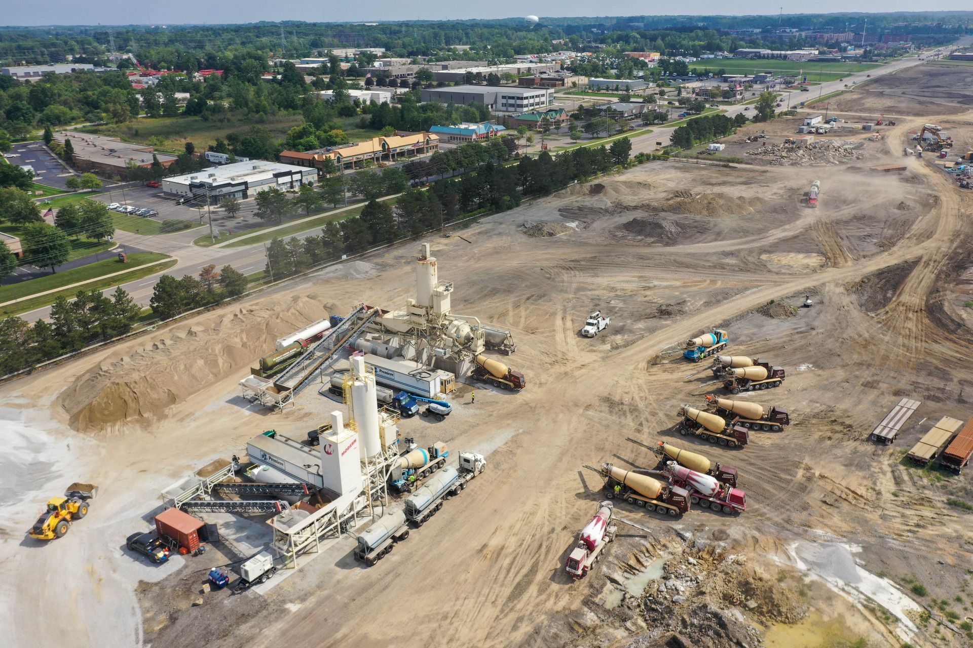 A concrete mixer truck is parked in a gravel lot