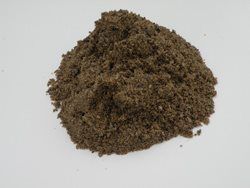 A pile of dirt is sitting on a white surface.