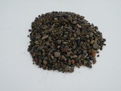 A pile of gravel is sitting on a white surface.