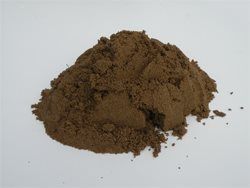 A pile of brown powder is sitting on a white surface.