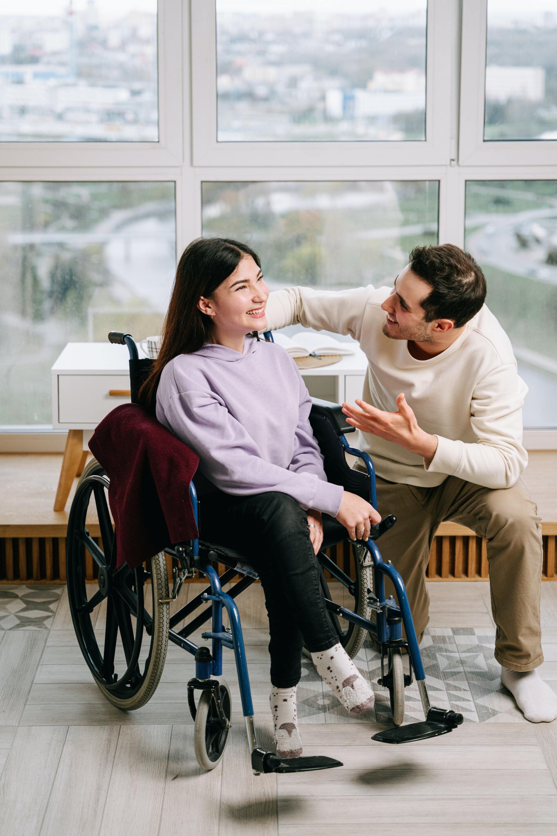 young girl in wheelchair talking to man