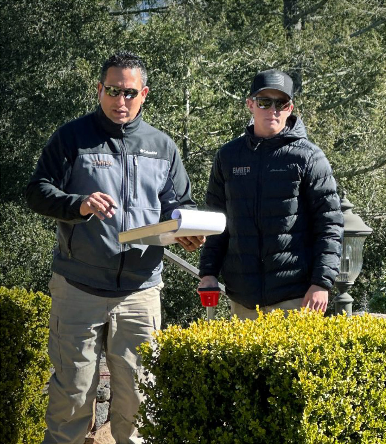 Two men standing next to each other with one holding a piece of paper