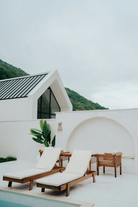 A white house with a swimming pool in front of it