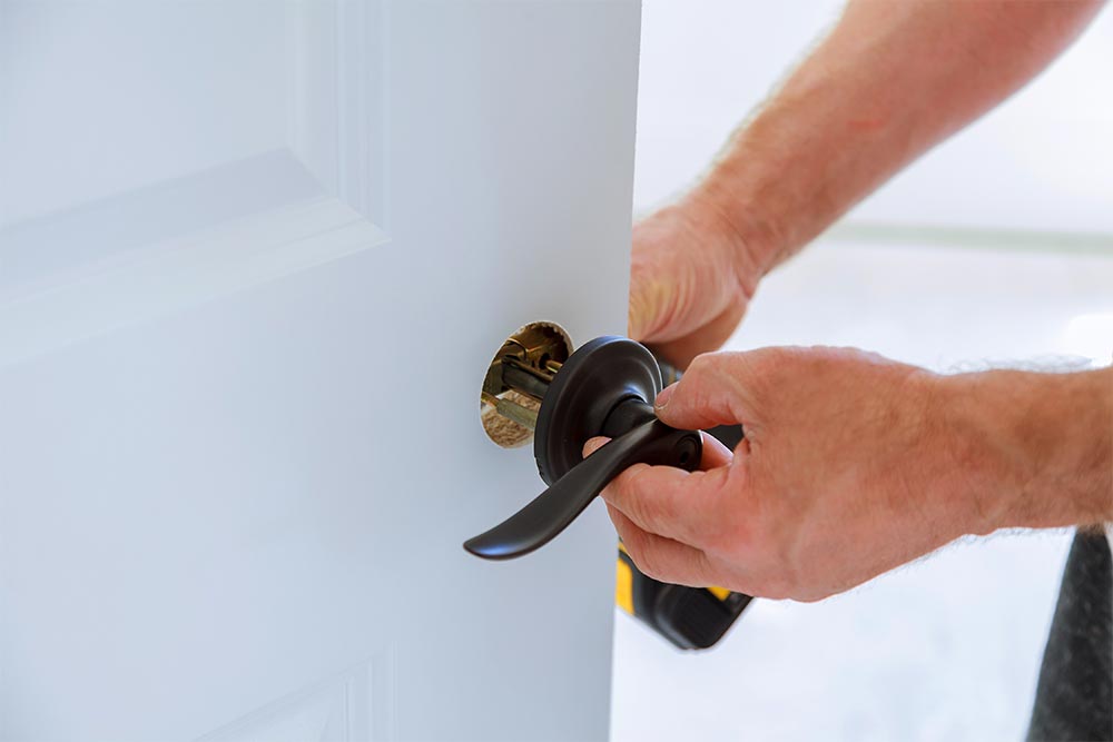 Carpenter Installing A Door Lock In Rockhampton