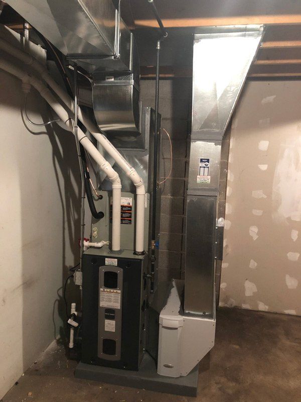 Furnace in basement with ductwork and a humidifier.