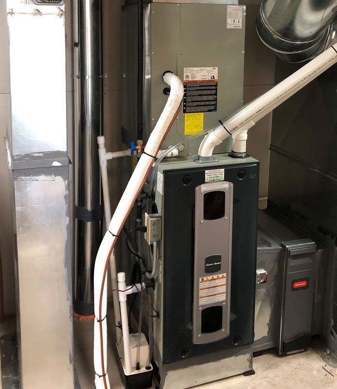 Furnace unit in a basement, with various pipes and ductwork.