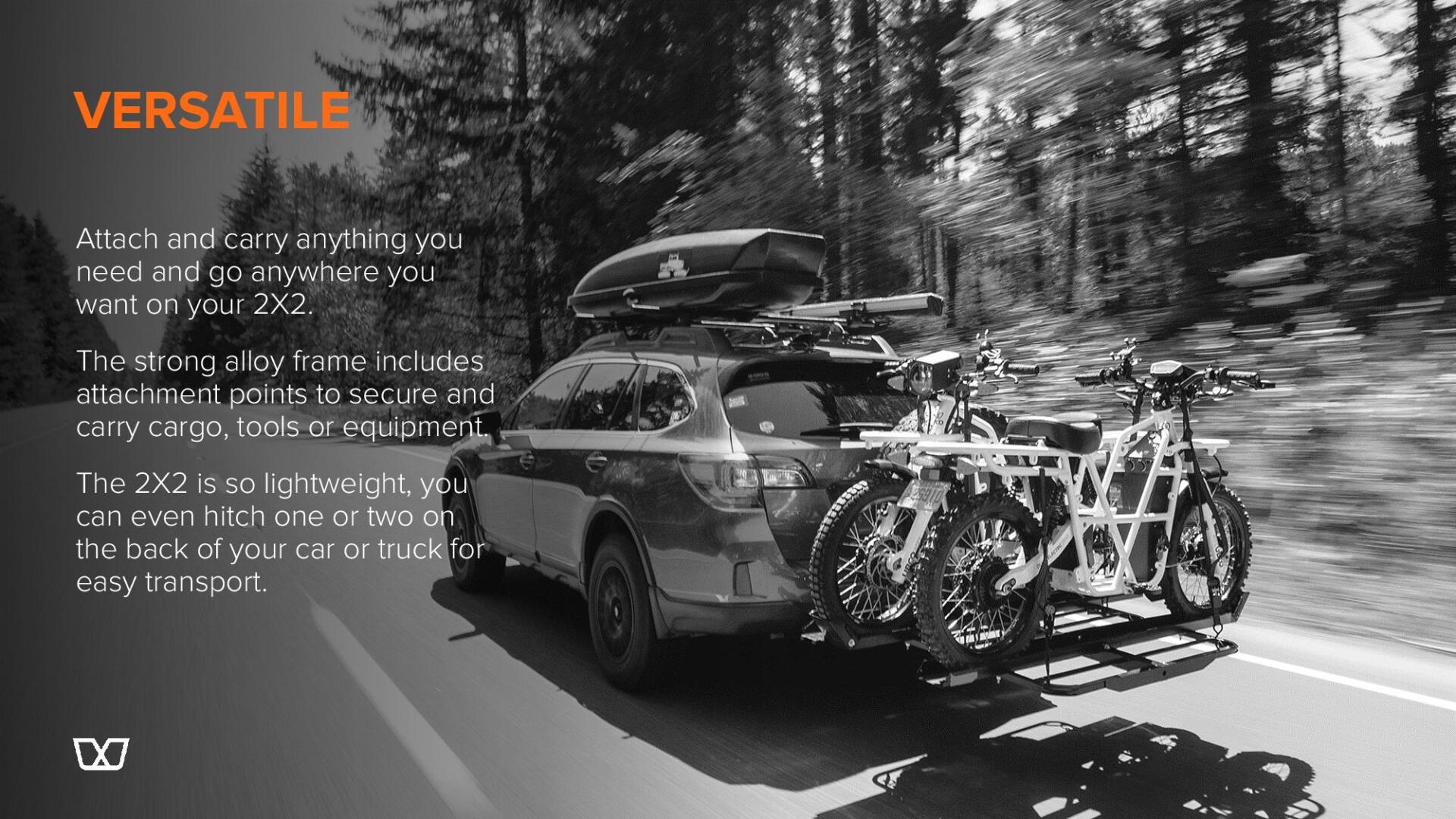A black and white photo of a car with two bikes attached to it.