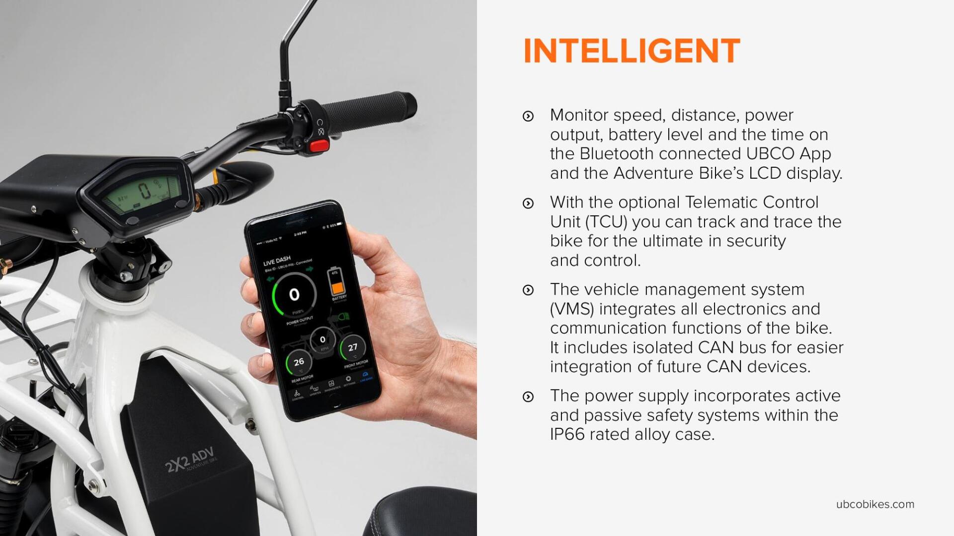 A person is holding a cell phone in front of a motorcycle.