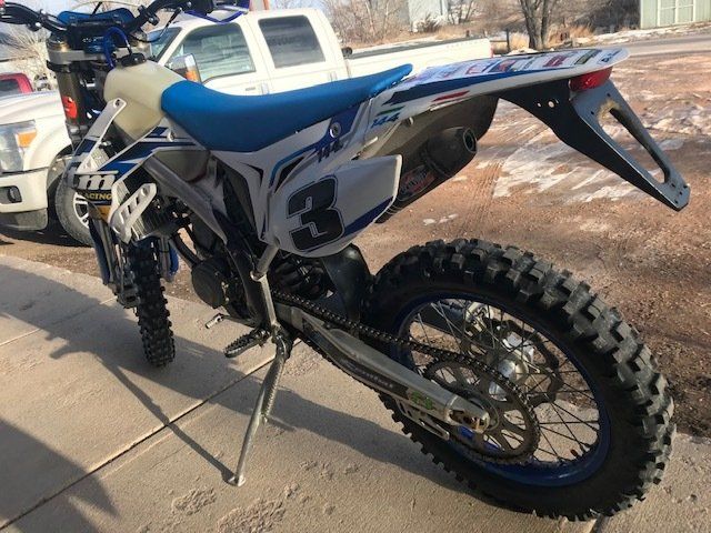 A blue and white dirt bike with the number 3 on it
