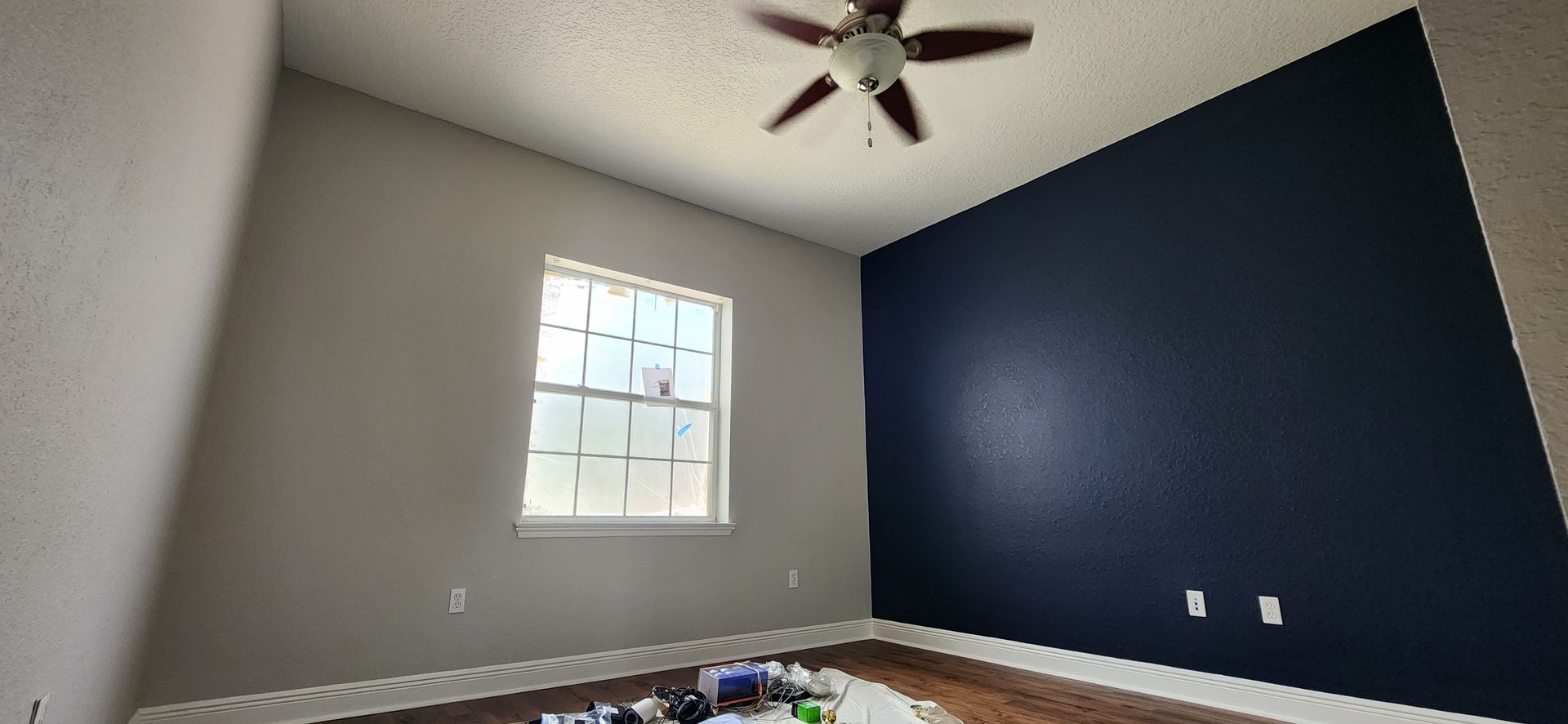 A room with a blue wall and a ceiling fan.