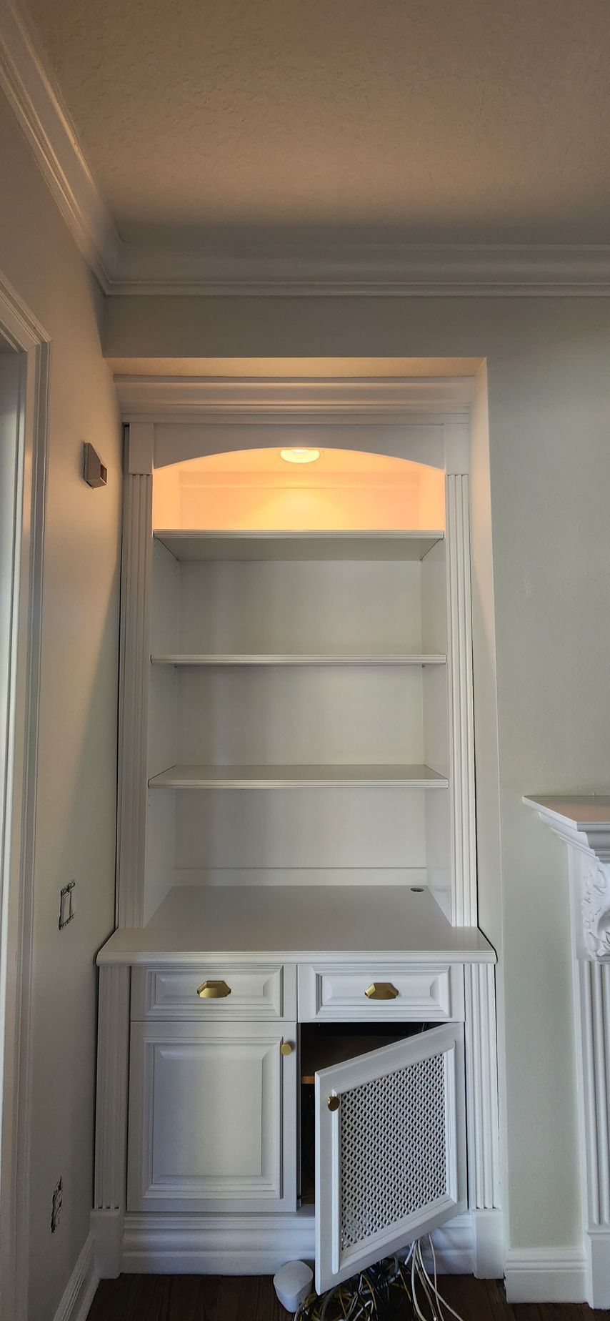 A white bookshelf with the door open in a room.