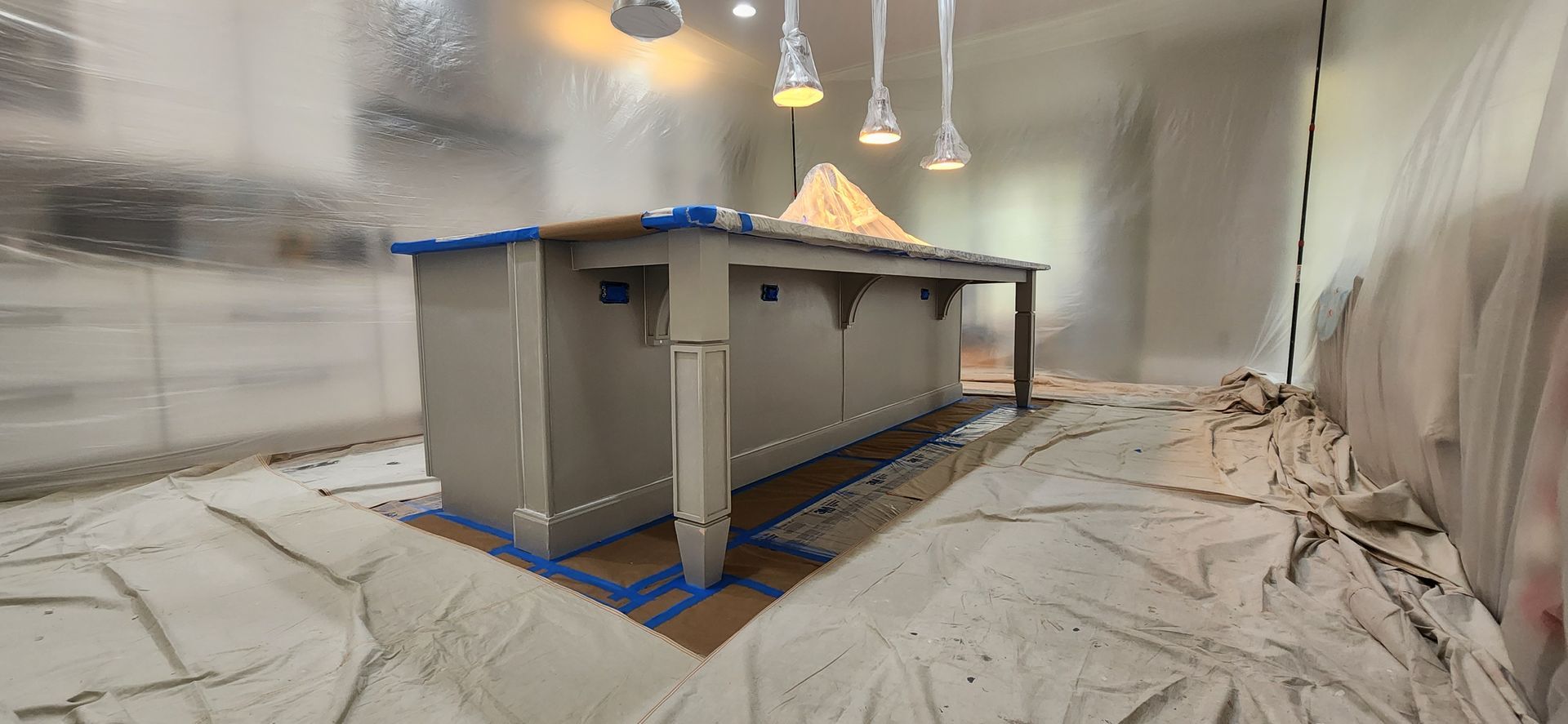 Bedroom with a bed, chair, windows with cream curtains, and a gray rug.