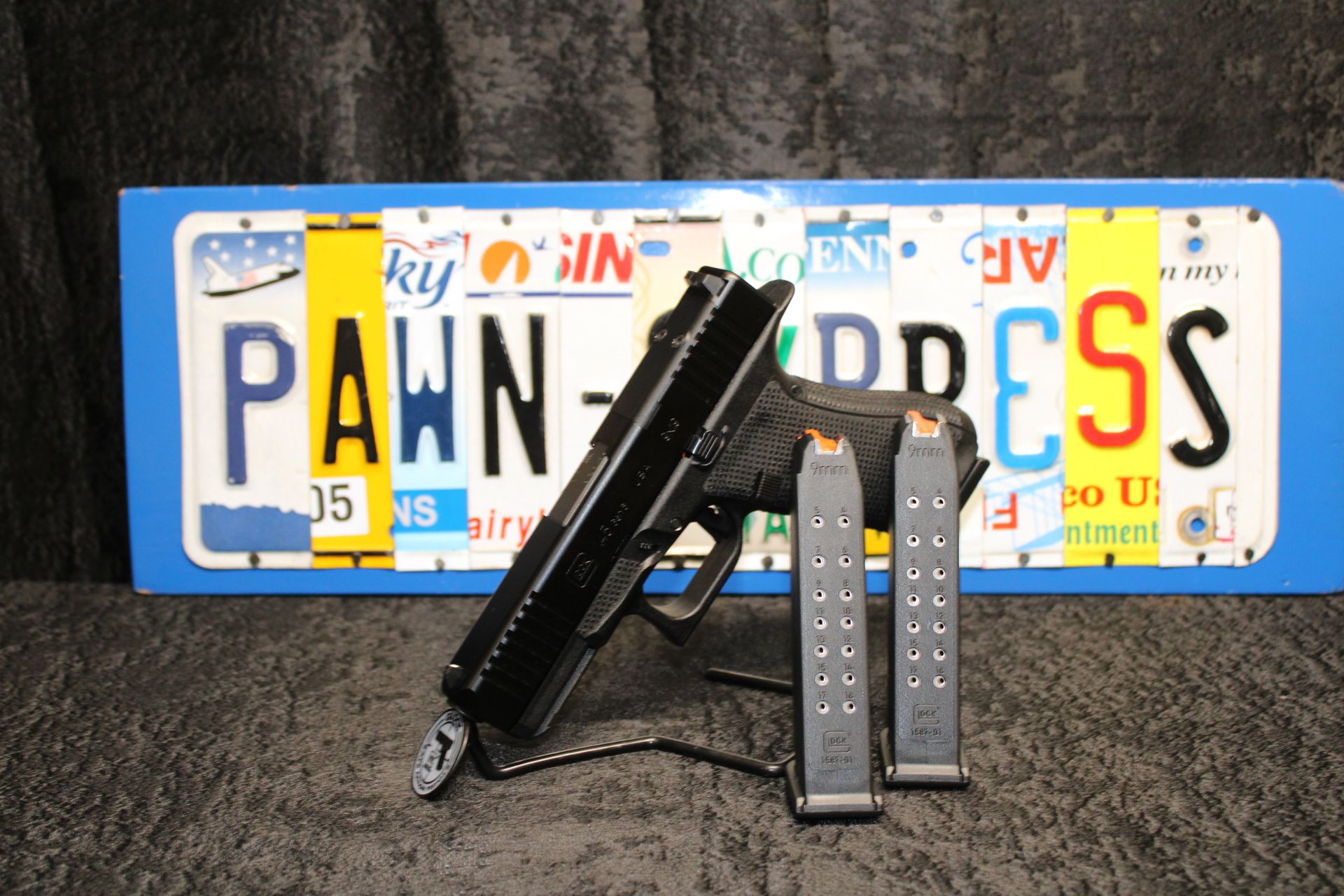 Handgun with two magazines in front of a Pennsylvania license plate background