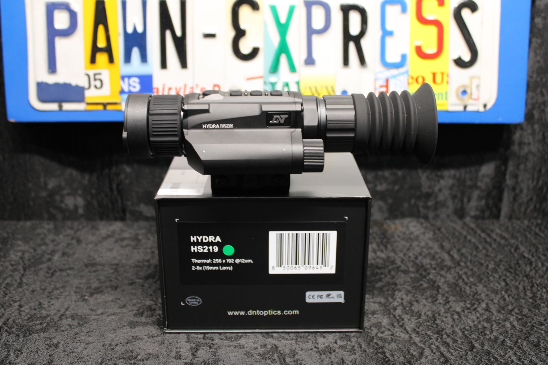 Black device with mounted flashlight in front of a Pennsylvania license plate