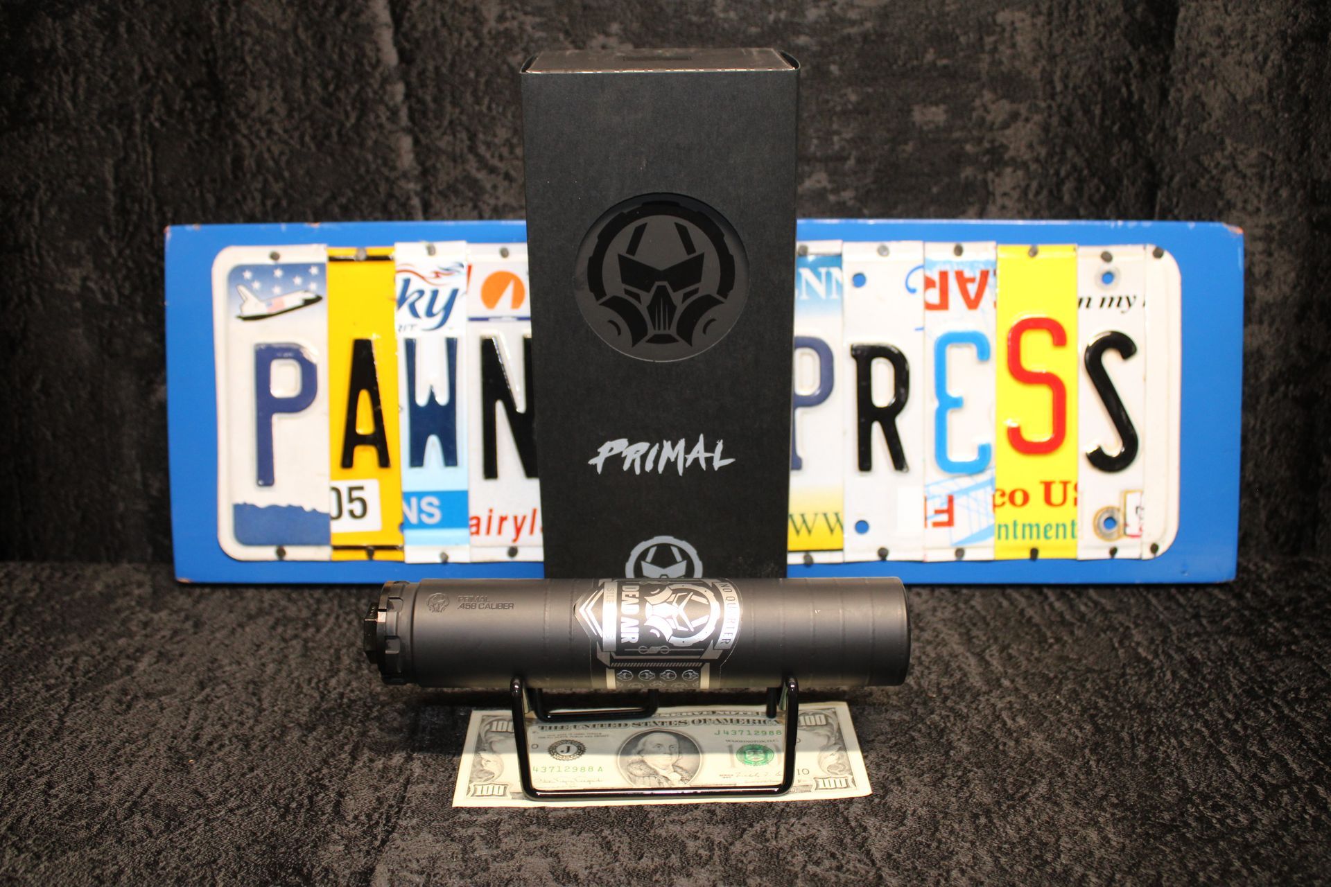 Black Primal foam roller displayed with two custom license plates reading “PAWN” and “PRESS” on a dark background
