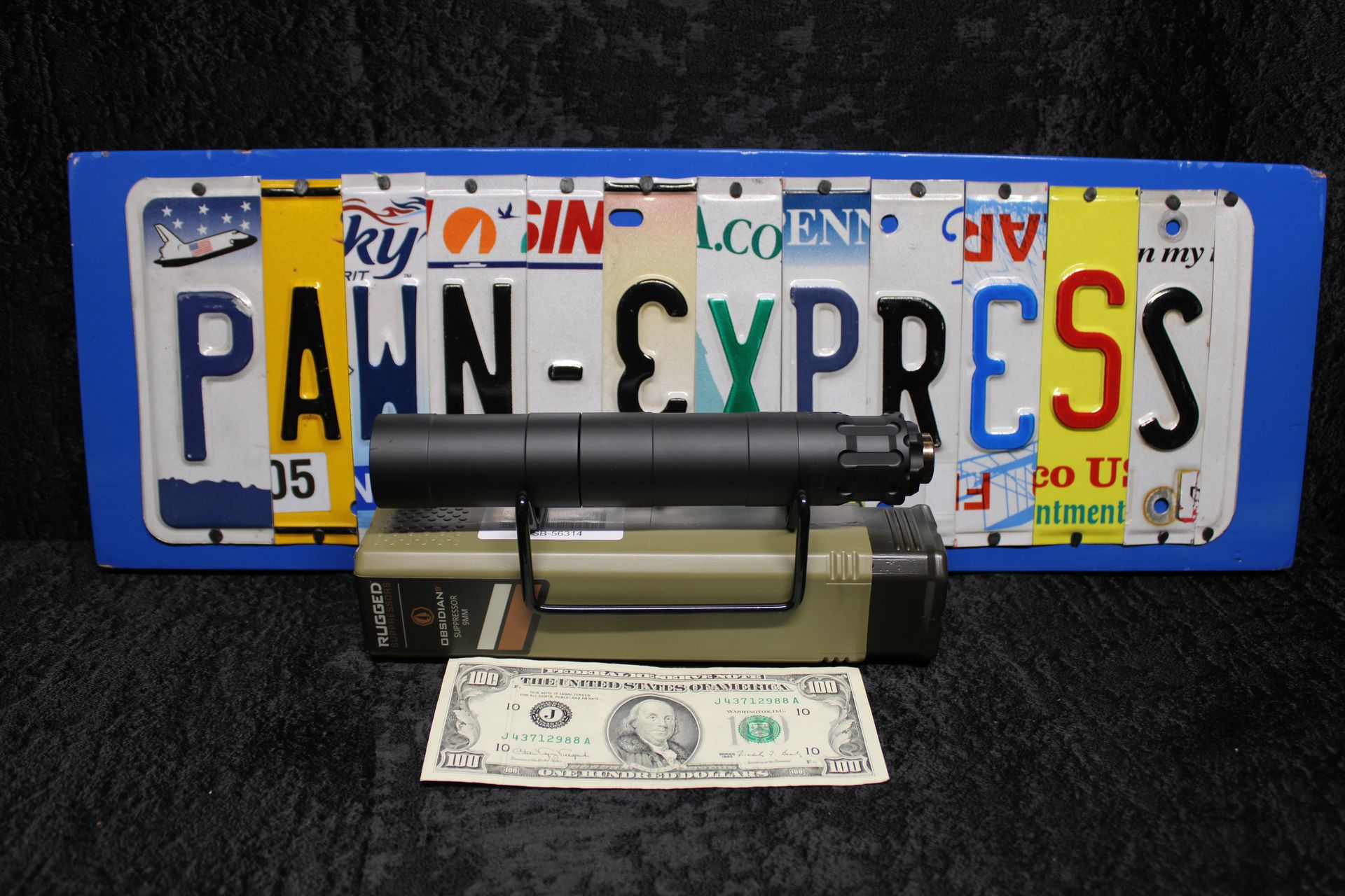 Pawn Express sign with a handgun and a dollar bill in front of it.
