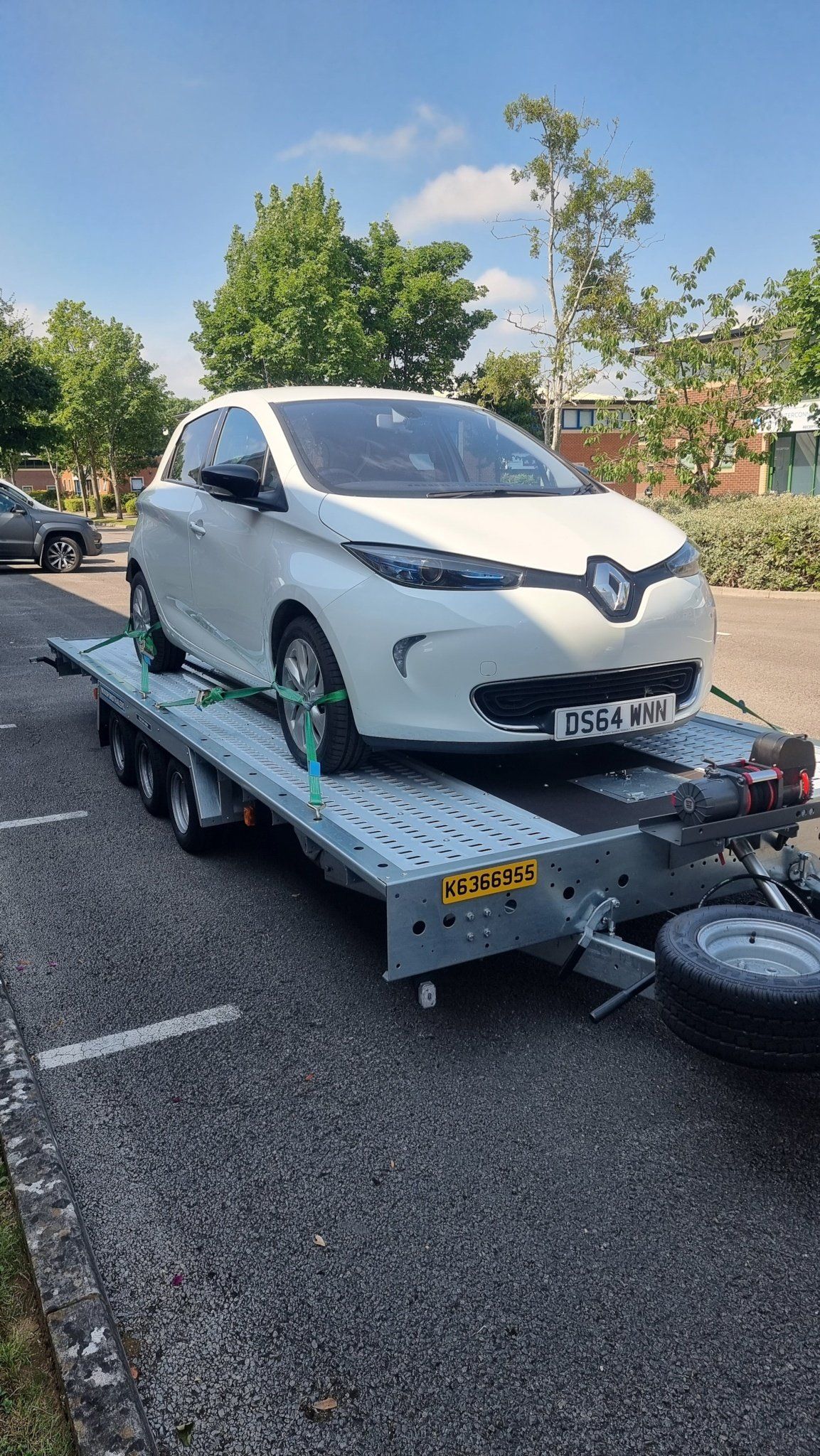 A white Renault on a trailer towed by a Mercedes Sprinter, ready for transport  by MTC Transport