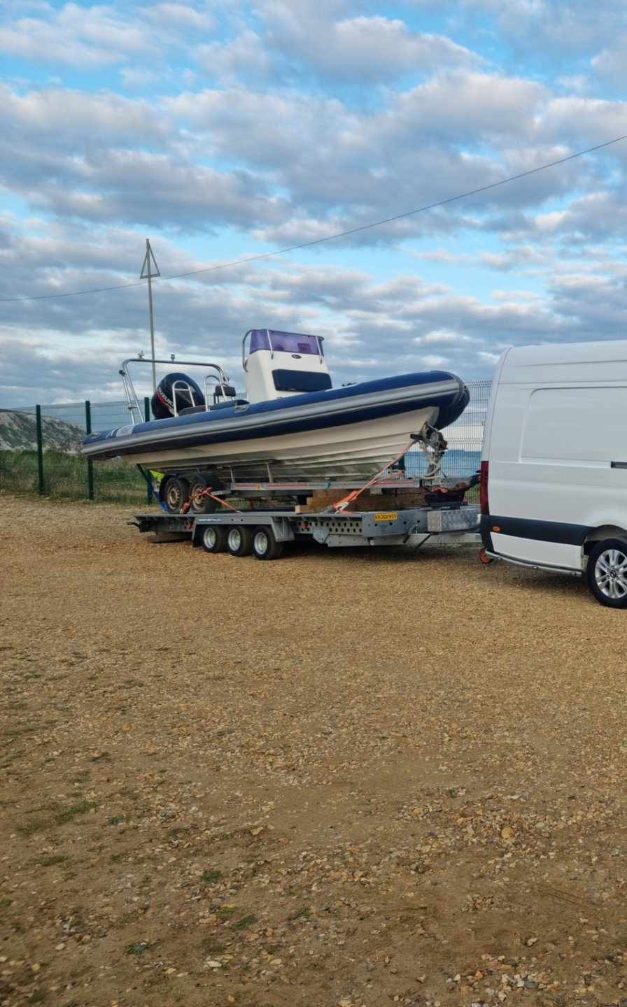 Boat and trailer loaded on a road trailer for transport by MTC